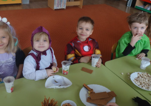 Dzieci jedzą karnawałowy poczęstunek
